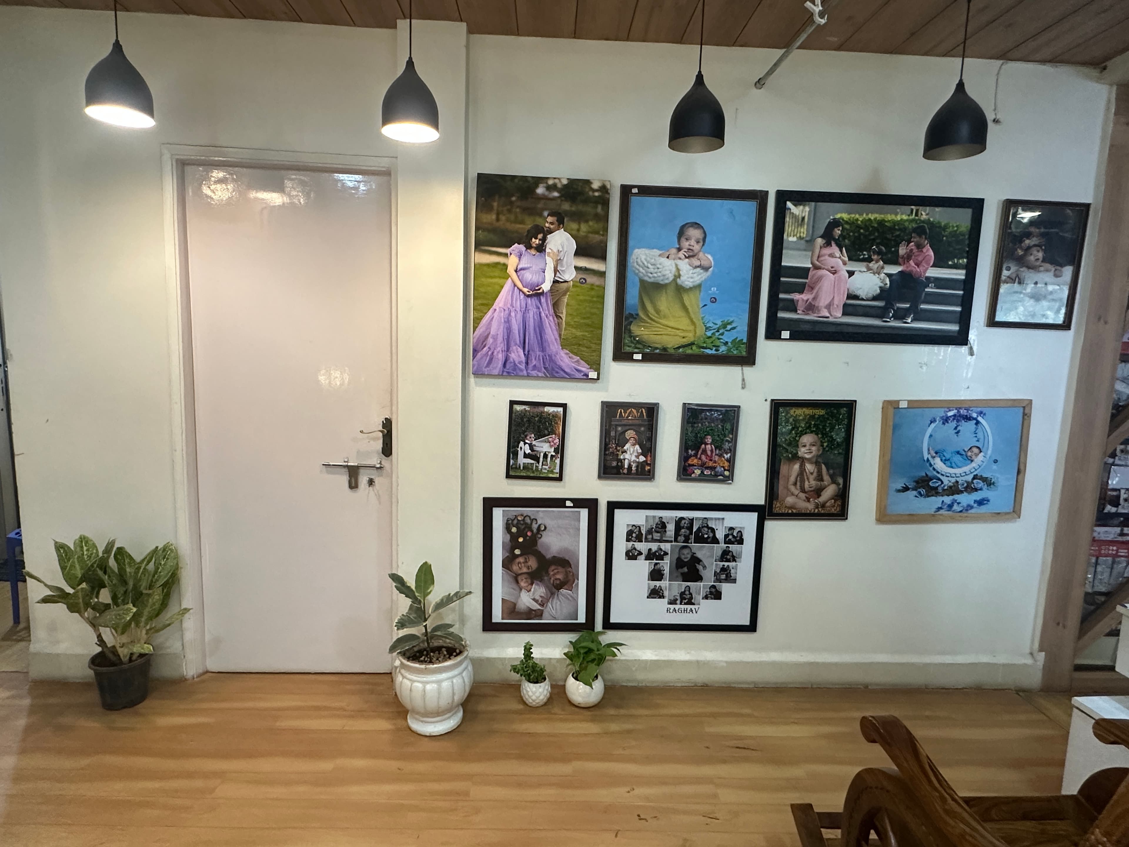 Portrait display wall with framed client photos inside the Pune baby studio