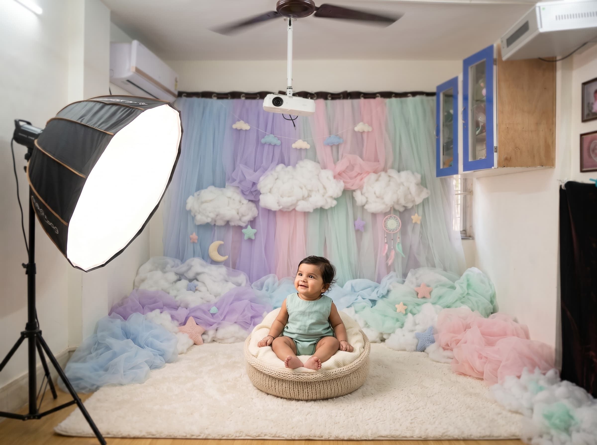 Three month baby smiling during a pastel cloud-themed studio photoshoot